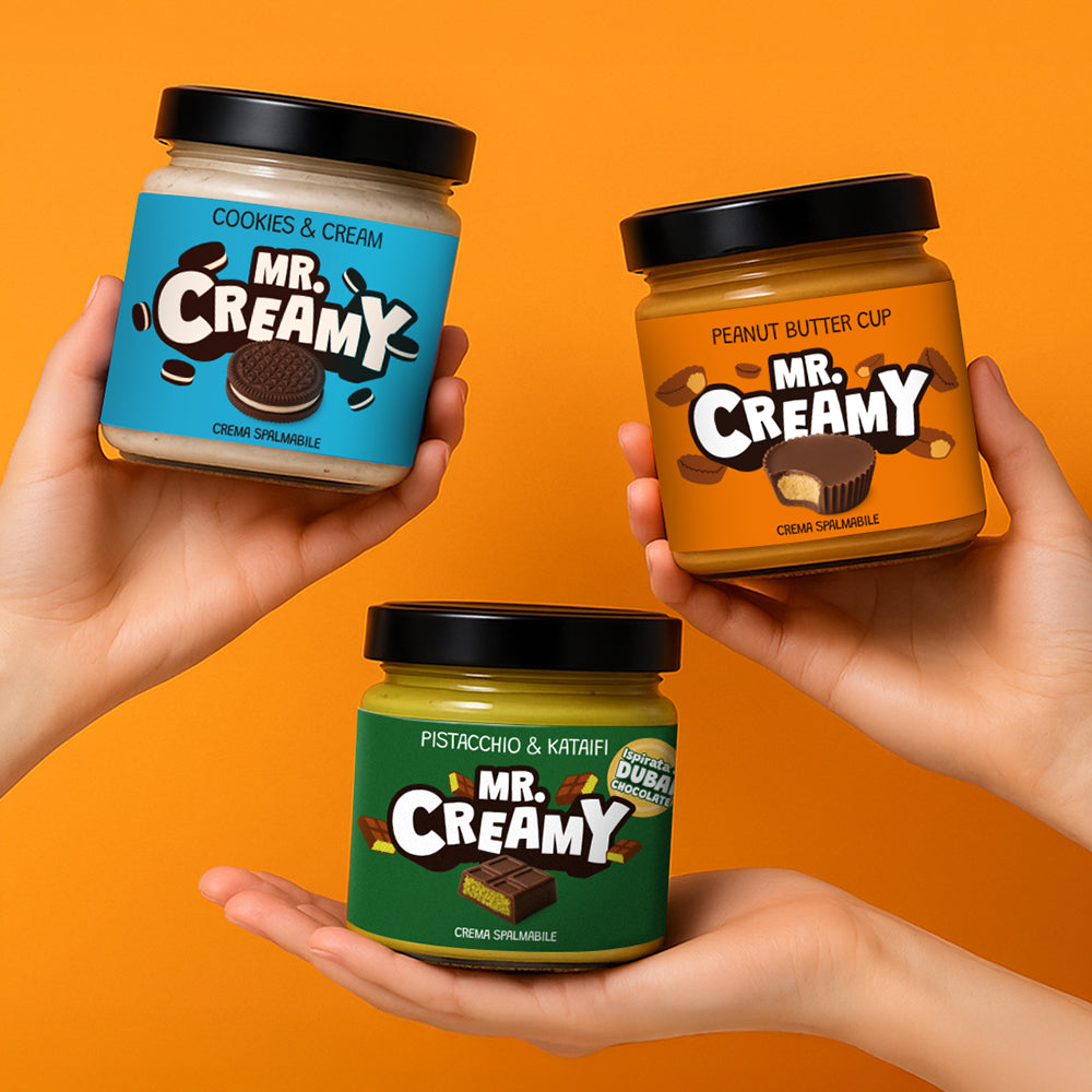 Combo Mr.Creamy "Pick&Mix", 3 creme spalmabili in gusti a scelta: nella foto mani che reggono cookies and cream, peanut butter cup, pistacchio e kataifi