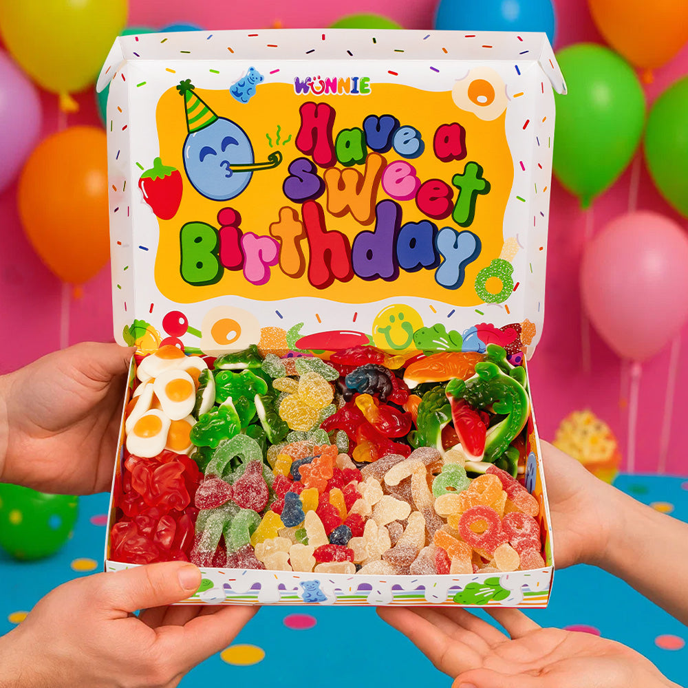 Scatola da 1kg Wunnie Box Birthday interno con scritta "Have a sweet birthday" con caramelle gommose e tenuta in mano